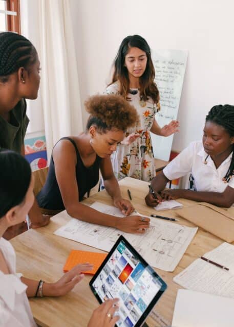 diverse group of women sat around a table analysing reports on organisational culture change