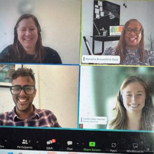 Photo of a laptop screen featuring a Zoom webinar. On screen you can see four cameras featuring the host and three panellists of this webinar.